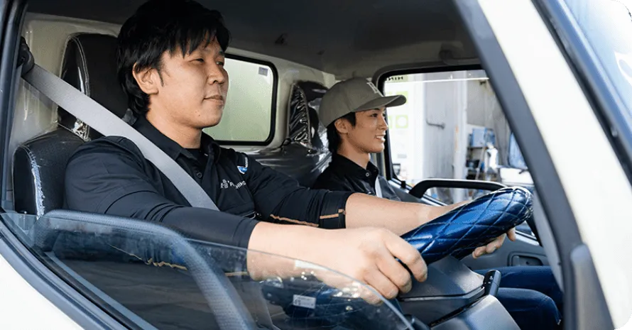 ゴミ回収車を運転する画像